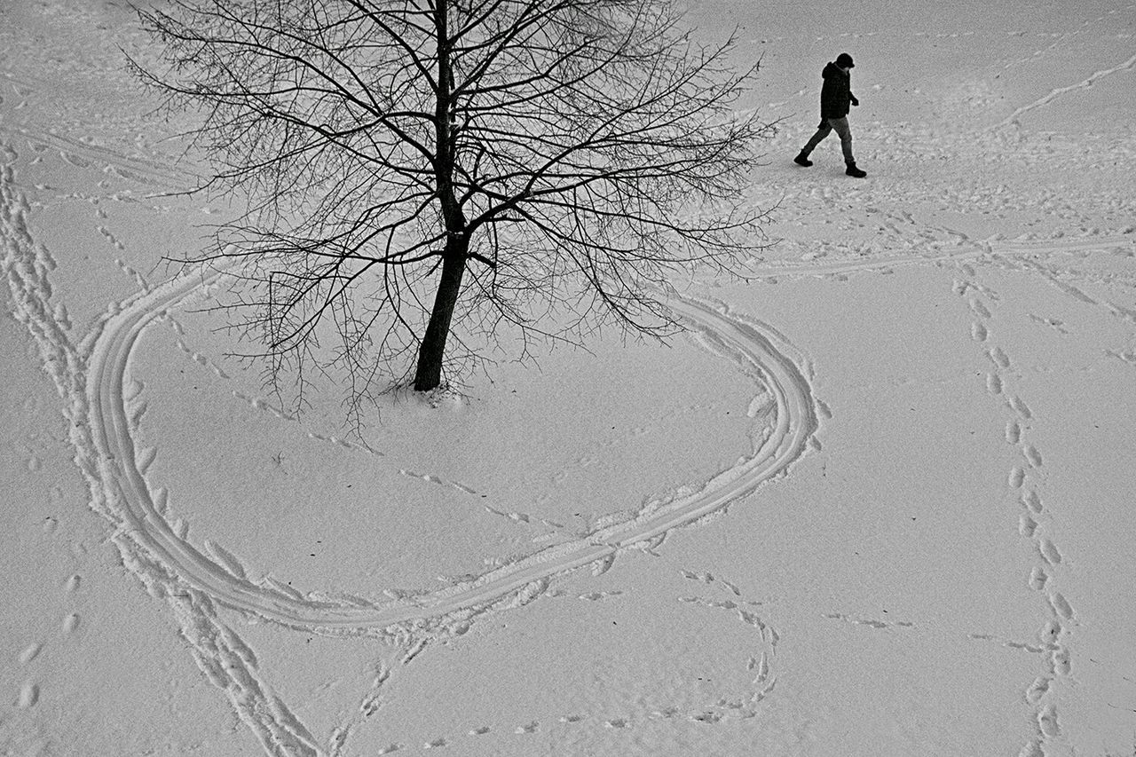 High angle view of man walking on snow covered field