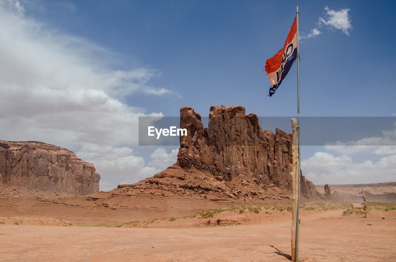 Low angle view of flag on desert against sky at the monument valley