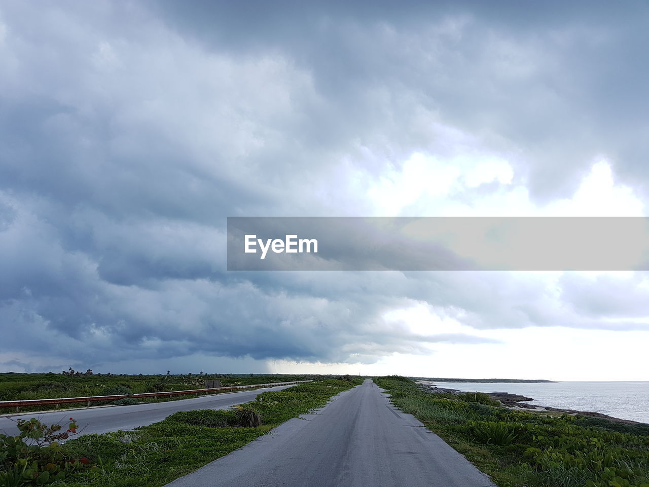 Road by sea against sky