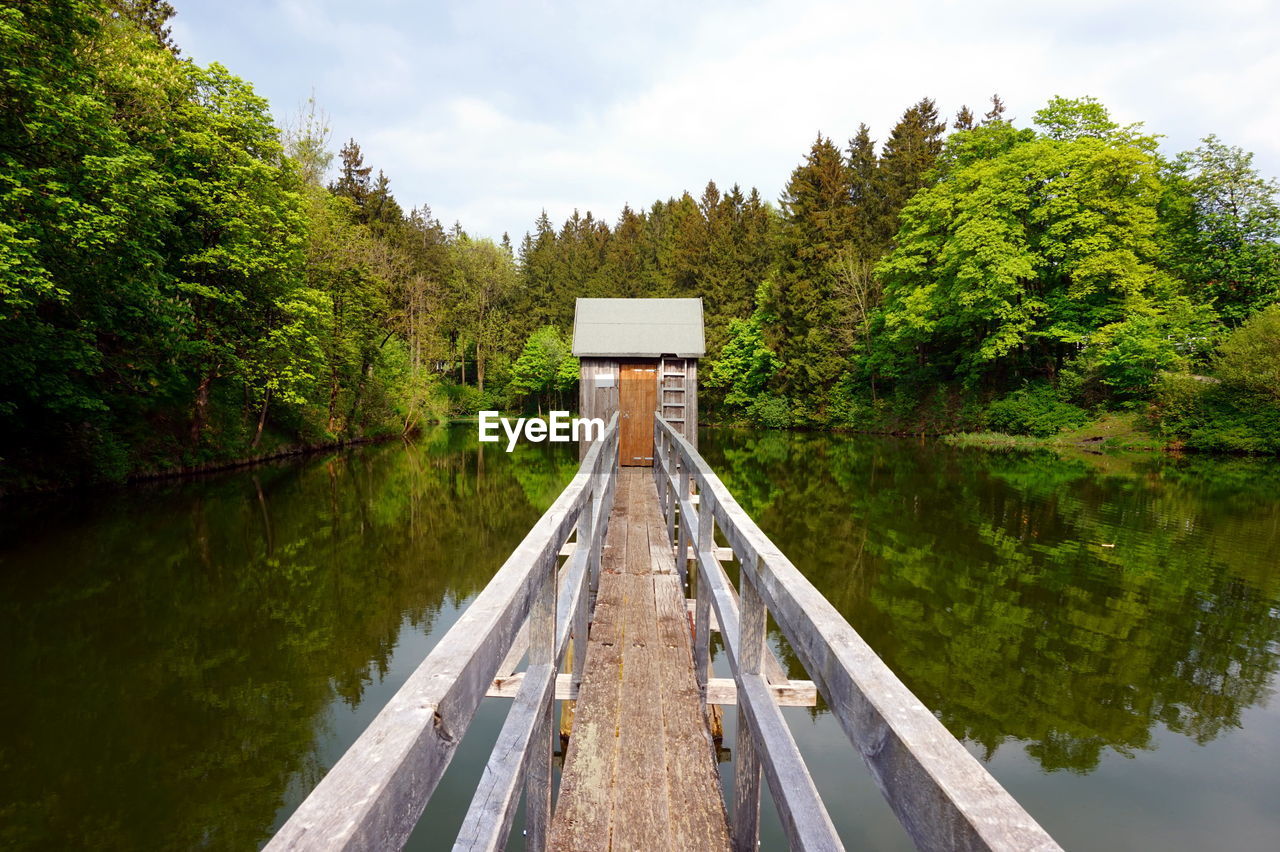 Footbridge leading towards wooden cottage