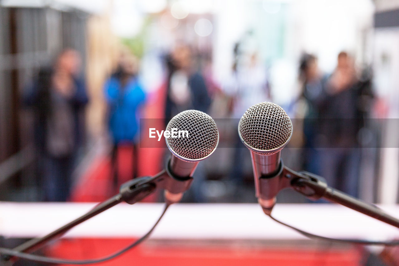 Close-up of microphones with people in background