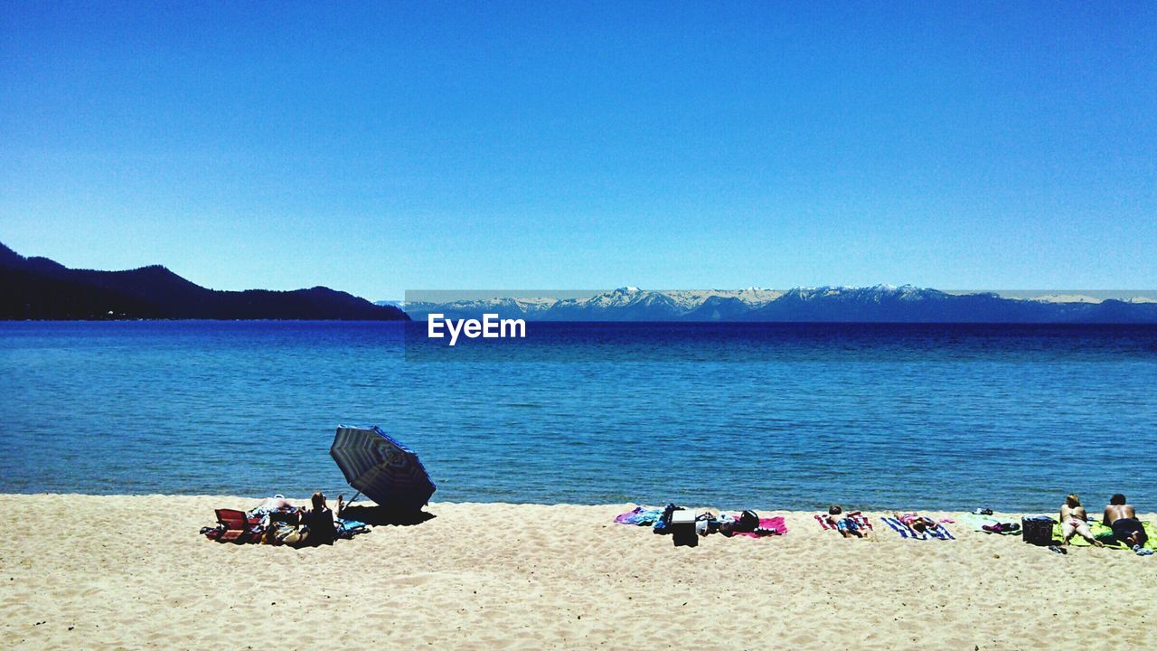 Scenic view of beach against clear blue sky