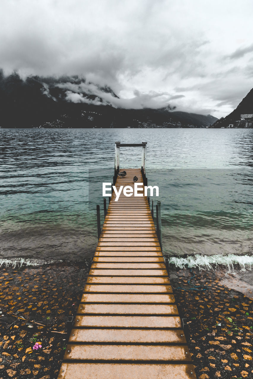 Boardwalk amidst sea against sky