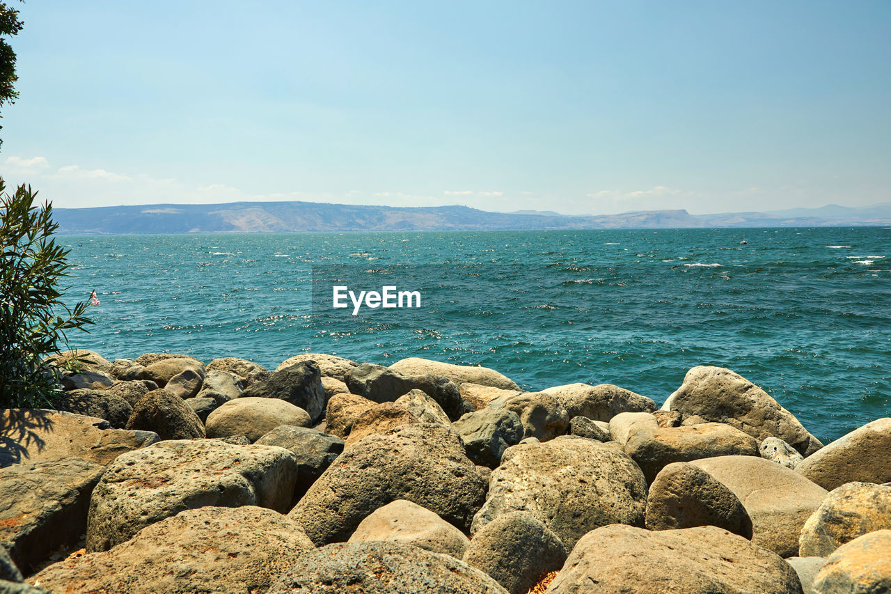 SCENIC VIEW OF ROCKS ON SEA AGAINST SKY