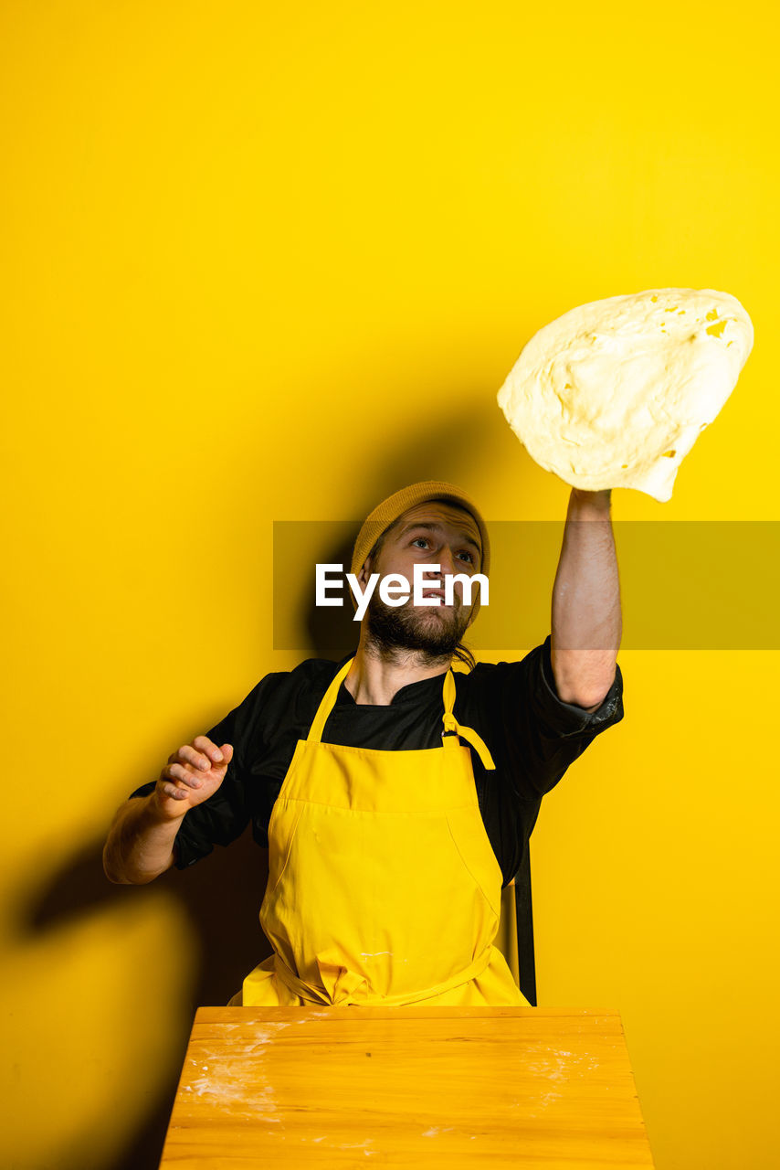 Chef preparing food against colored background