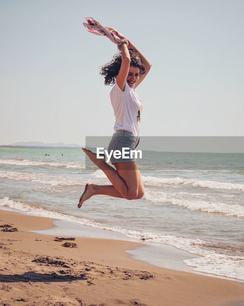 Full length of woman jumping on beach