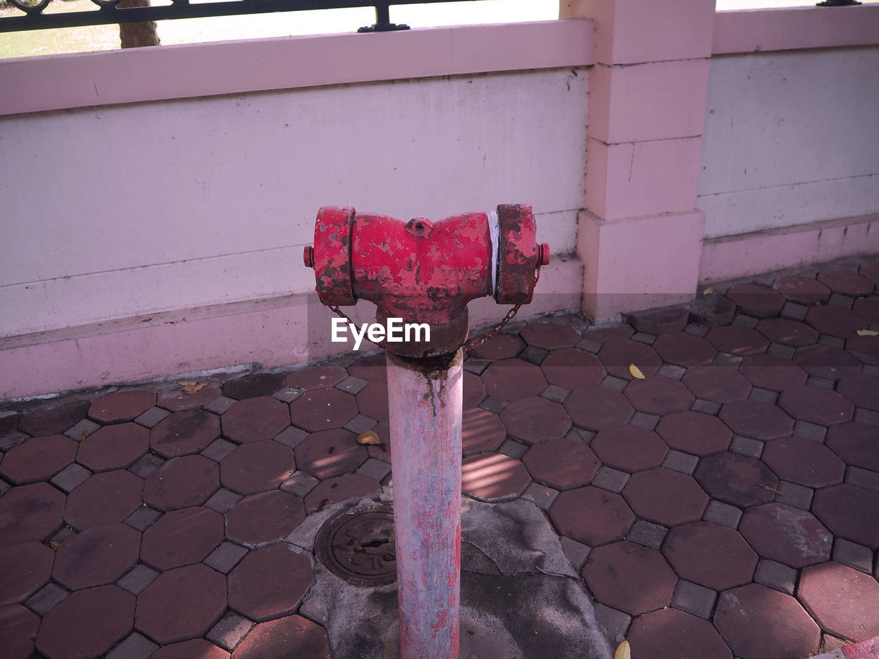 CLOSE-UP OF RED FIRE HYDRANT ON FOOTPATH