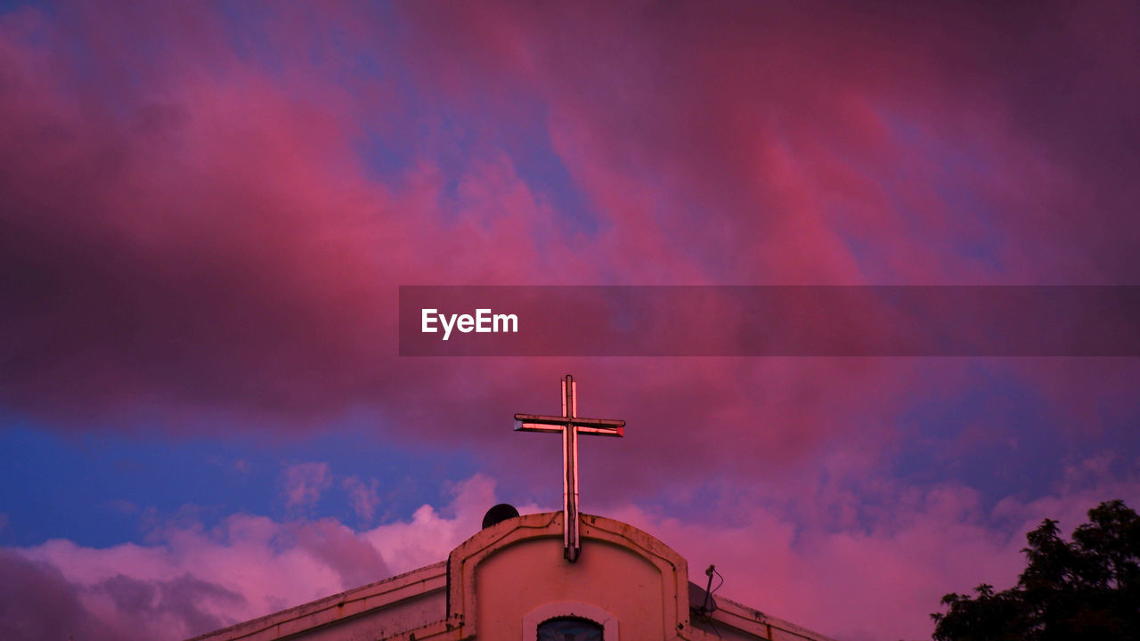 LOW ANGLE VIEW OF ILLUMINATED BUILDING AGAINST SKY DURING SUNSET