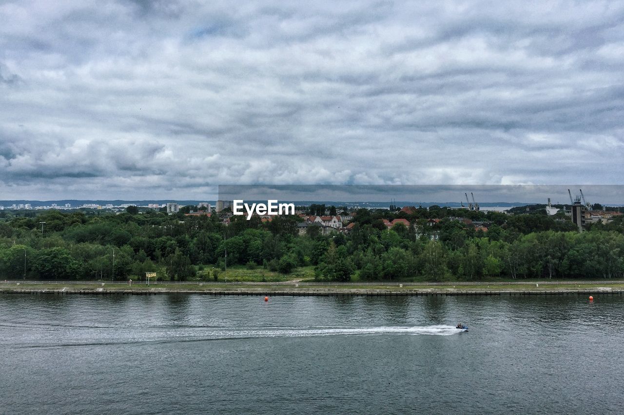 Scenic view of river against cloudy sky