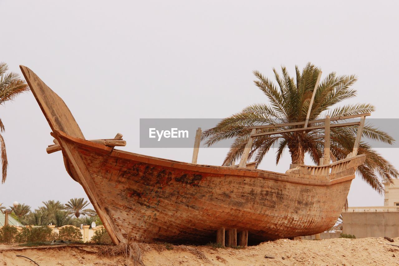 Low angle view of abandoned boat on beach against sky