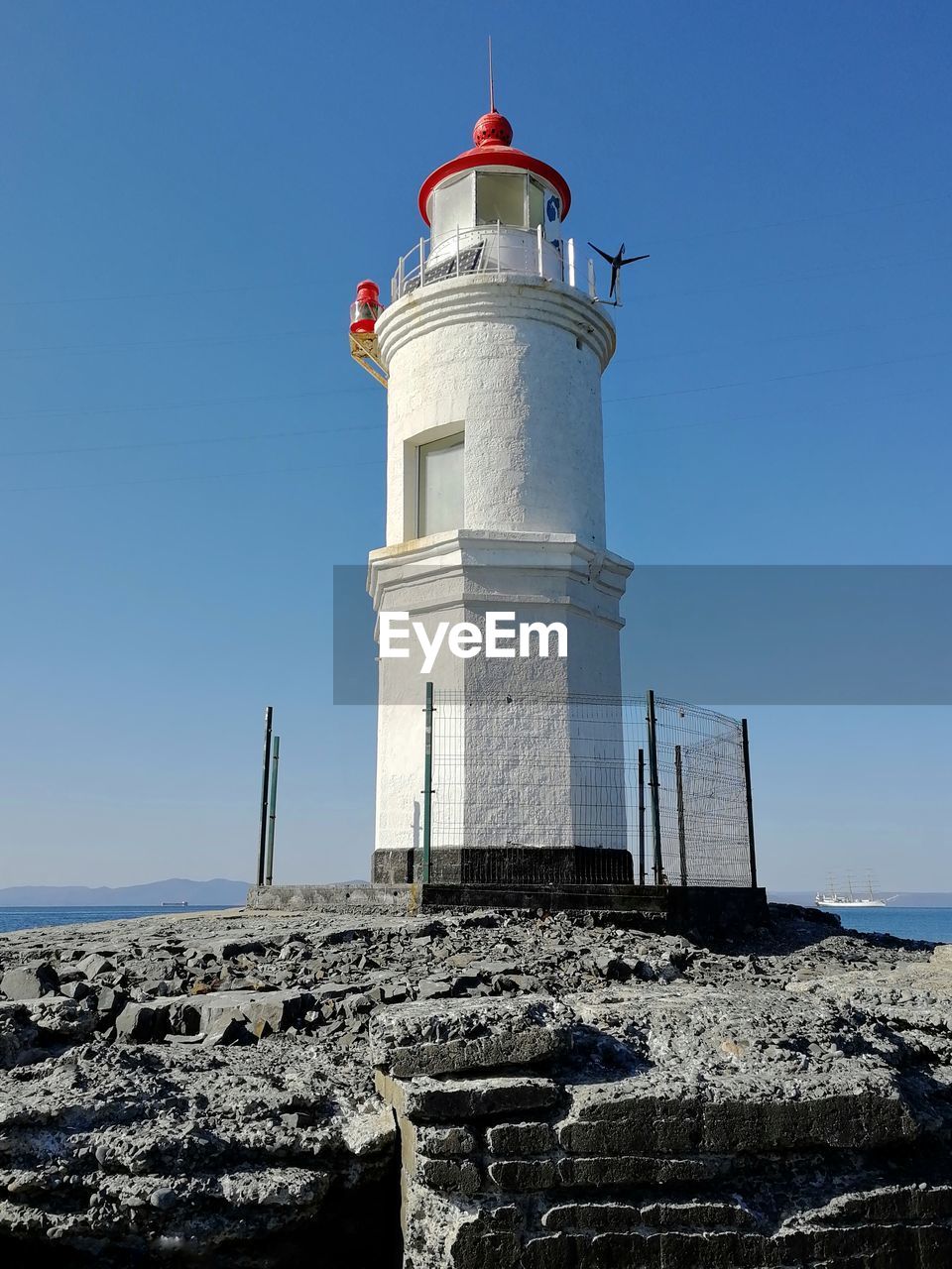 LIGHTHOUSE BY BUILDING AGAINST SKY