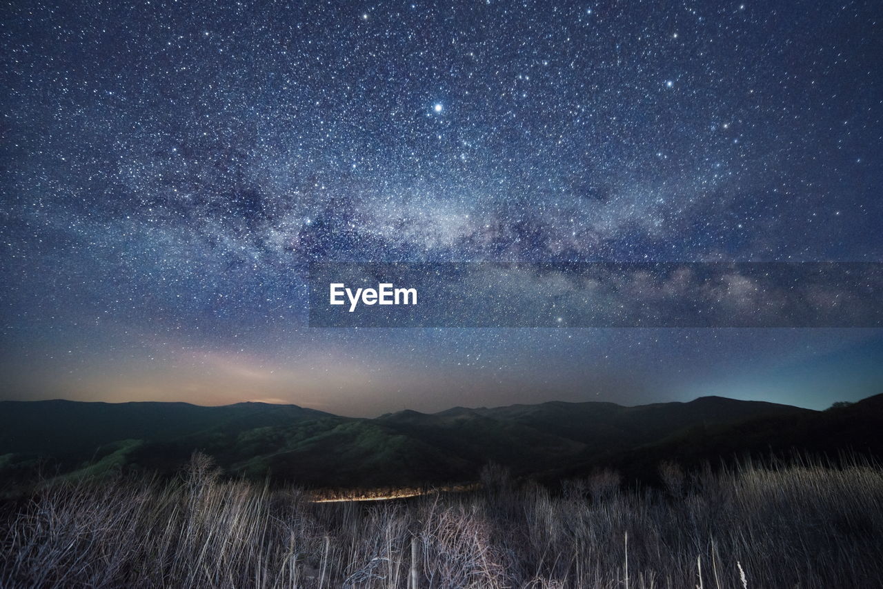 Scenic view of mountains against sky at night