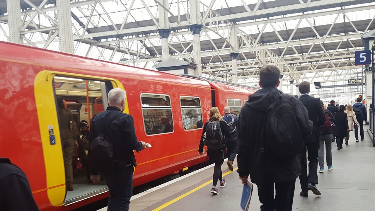 REAR VIEW OF PEOPLE ON TRAIN AT RAILROAD STATION PLATFORM