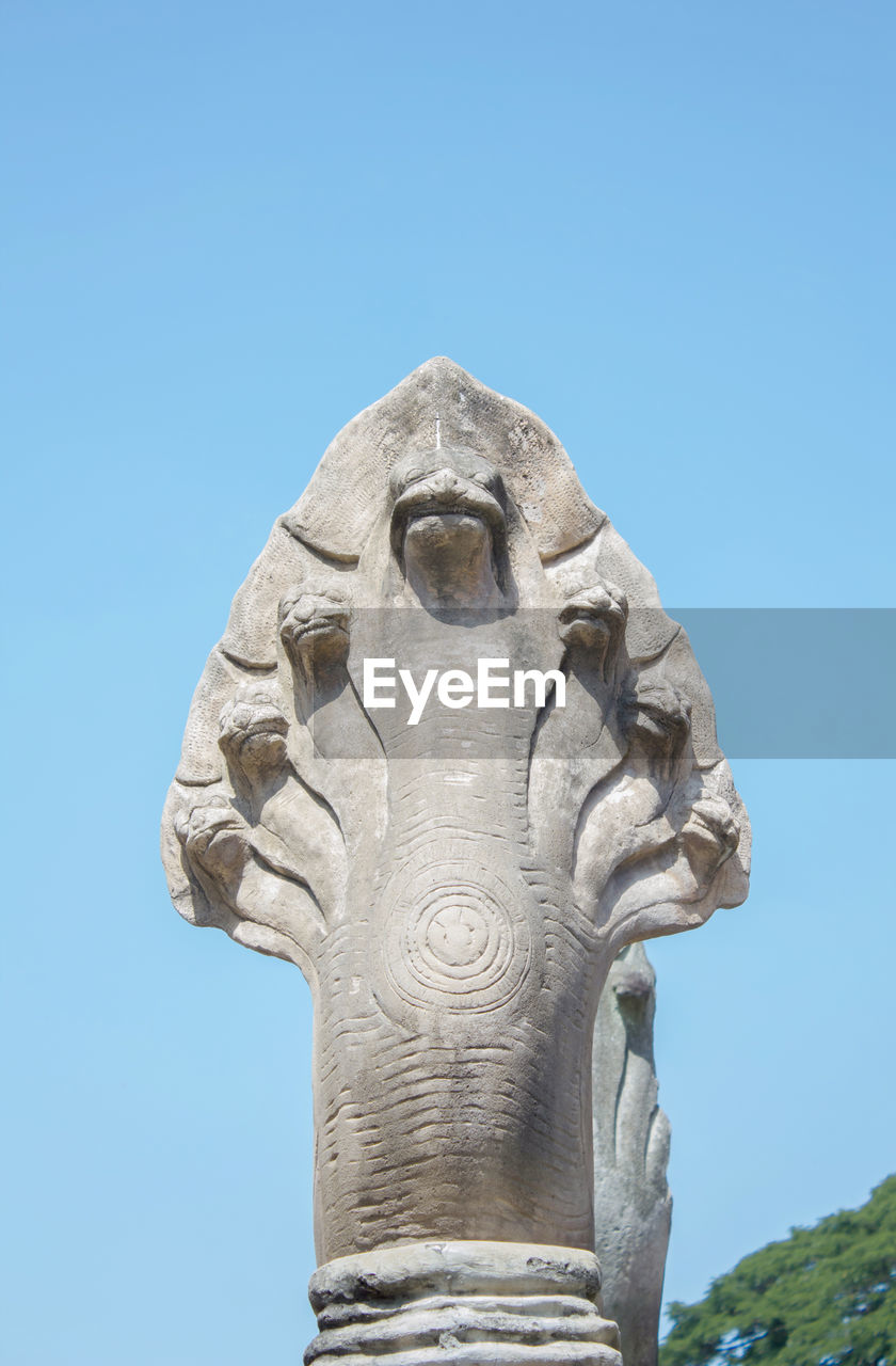 Low angle view of snake statue against clear blue sky