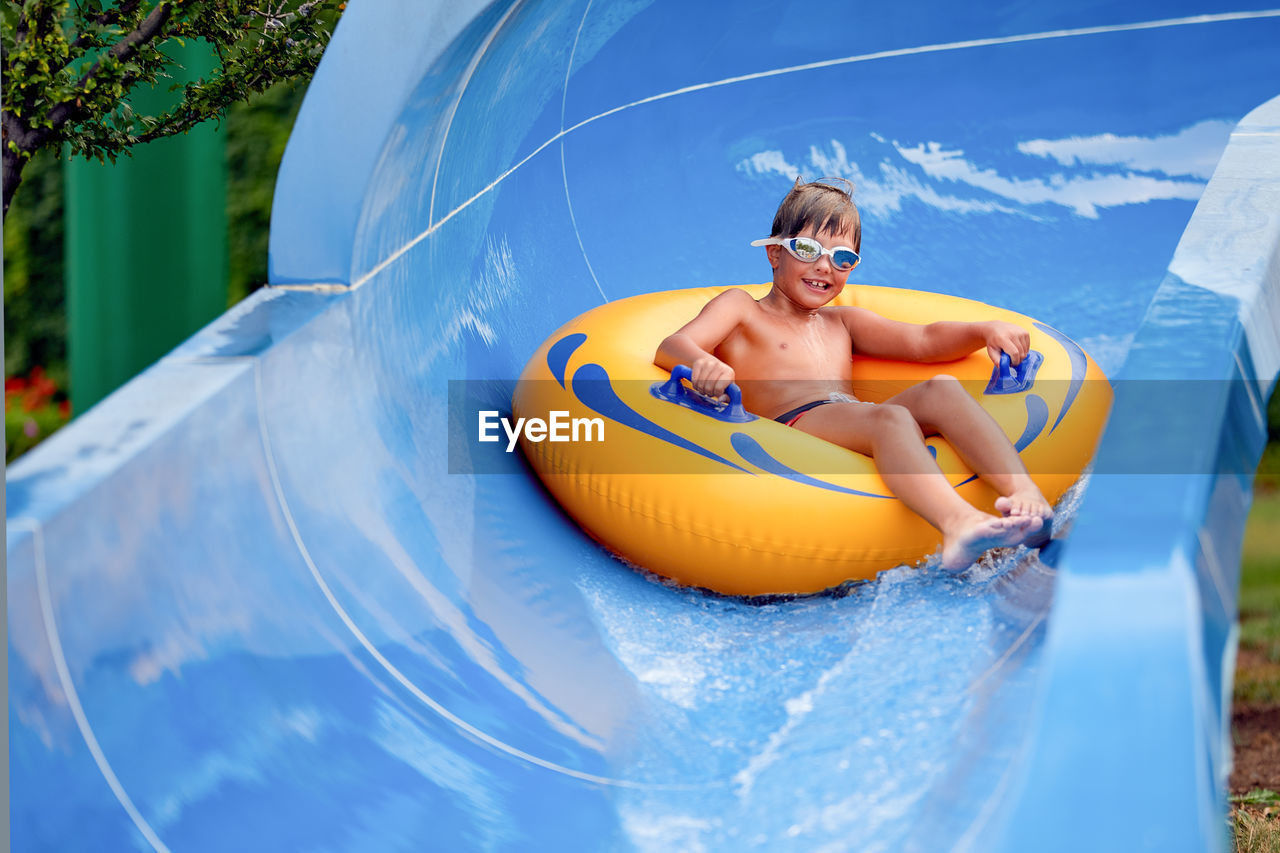 Portrait of cute boy sitting on inflatable ring