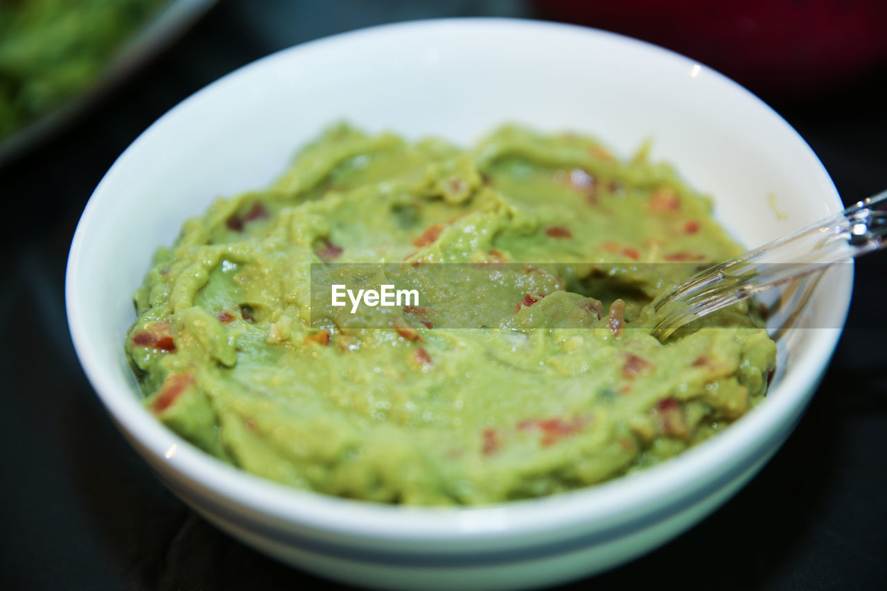 Freshly made guacamole in an isolated white bowl