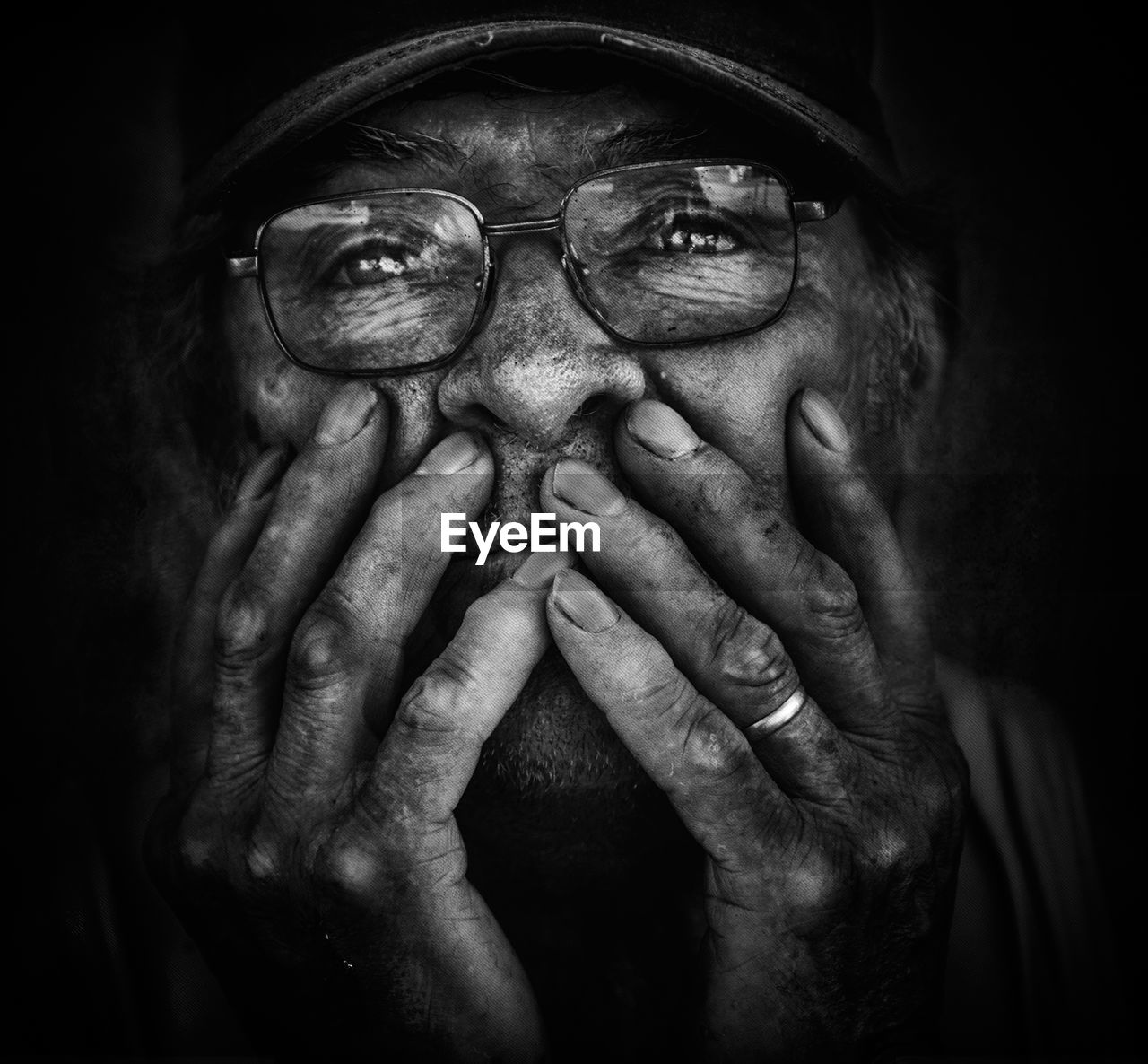 Close-up of senior man wearing eyeglasses against black background