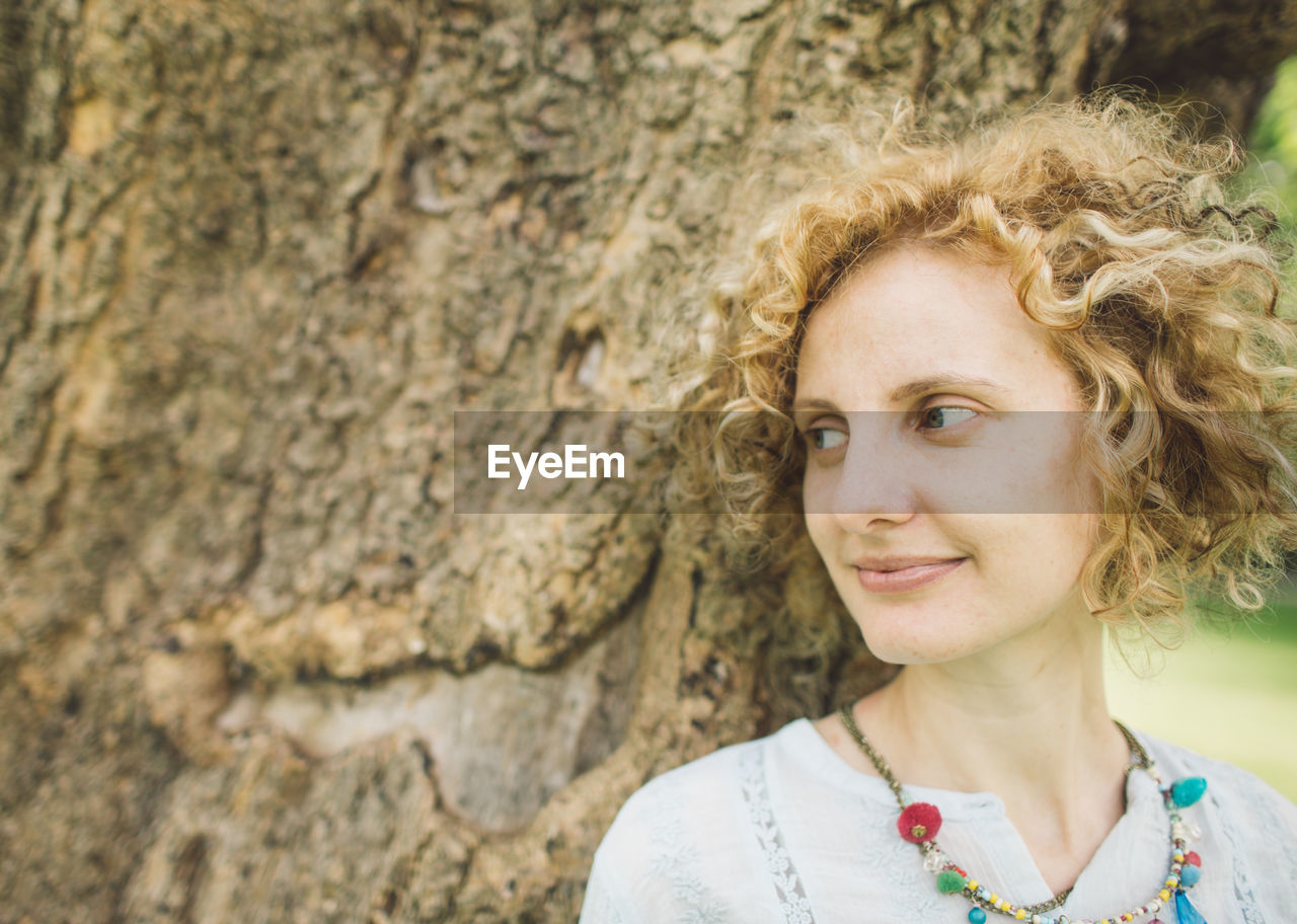 PORTRAIT OF SMILING WOMAN OUTDOORS