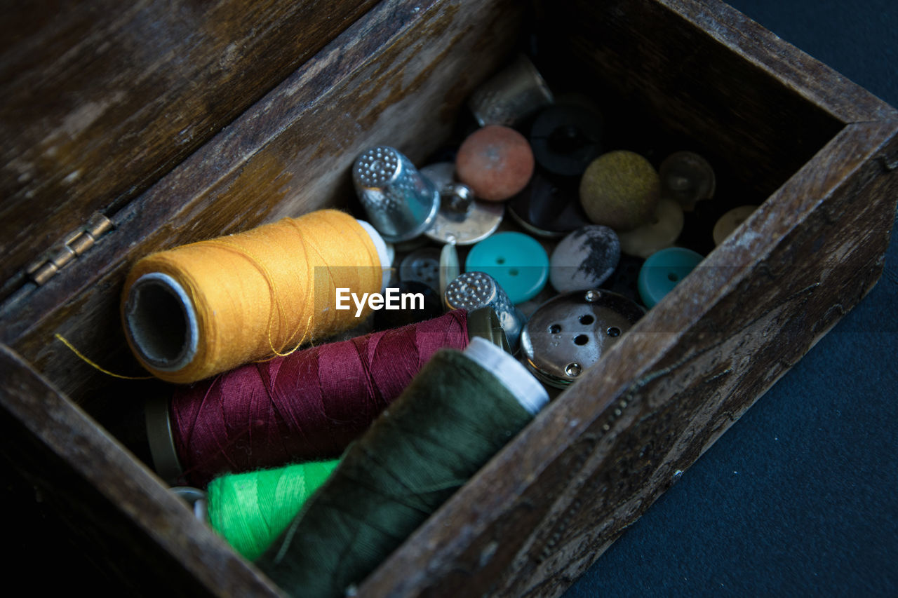 High angle view of sewing items in wooden container