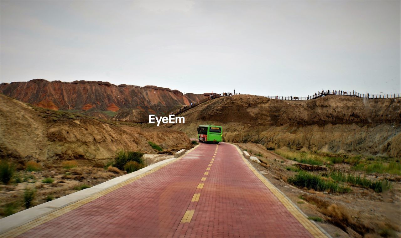 Road leading towards mountain against clear sky