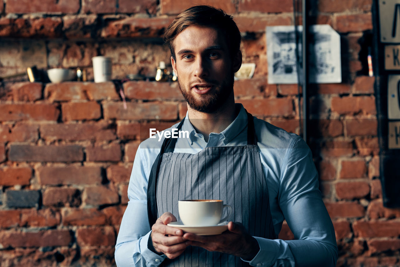 Portrait of young man drinking coffee