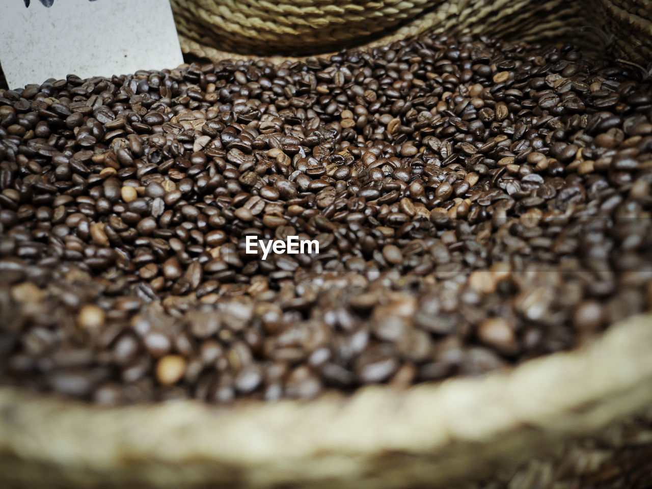 Close-up of roasted coffee beans in wicker basket in store