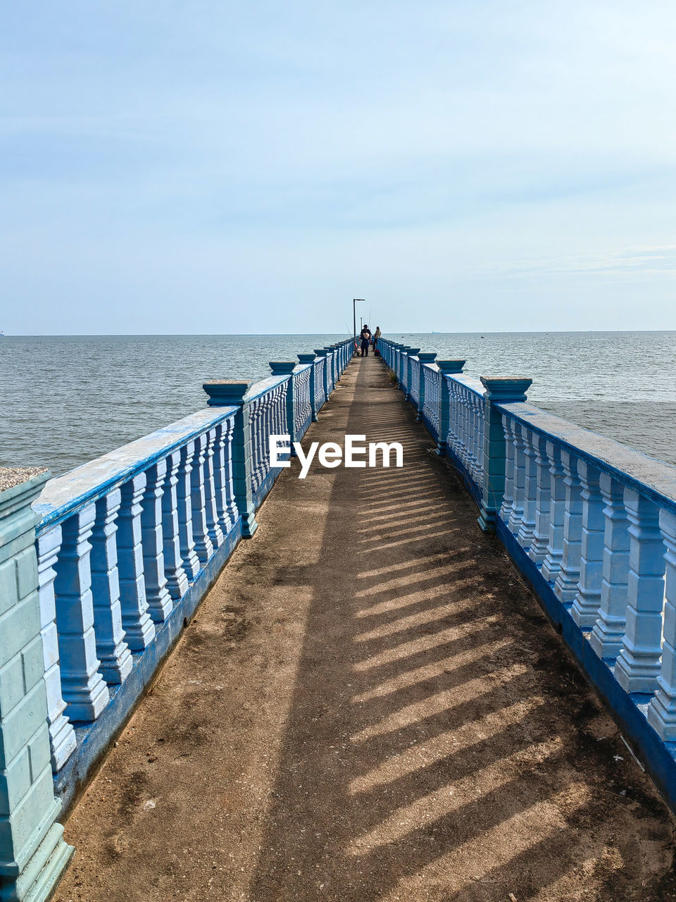 water, sea, horizon over water, walkway, horizon, sky, the way forward, nature, beach, railing, scenics - nature, beauty in nature, pier, tranquility, blue, tranquil scene, day, land, diminishing perspective, boardwalk, coast, no people, sunlight, ocean, outdoors, idyllic, architecture, footpath, vanishing point, wood, non-urban scene, built structure, cloud, transportation, sand, shore