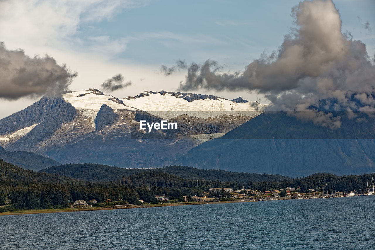 Scenic view of lake by mountains against sky