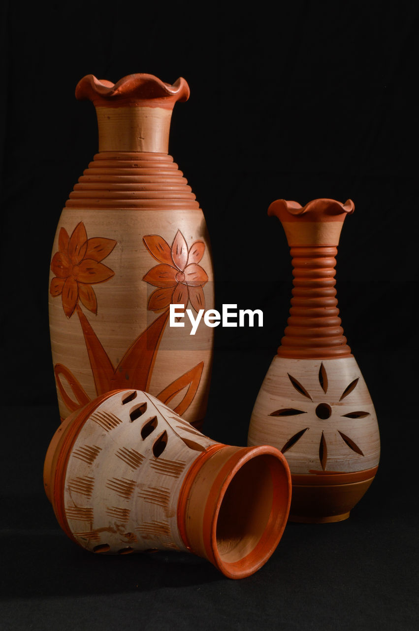 Still life with hand painted and hand made isolated close-up of vase against black background