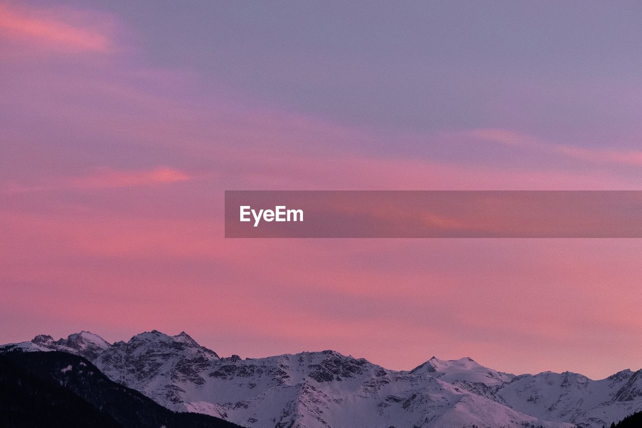 Scenic view of snowcapped mountains against sky during sunset