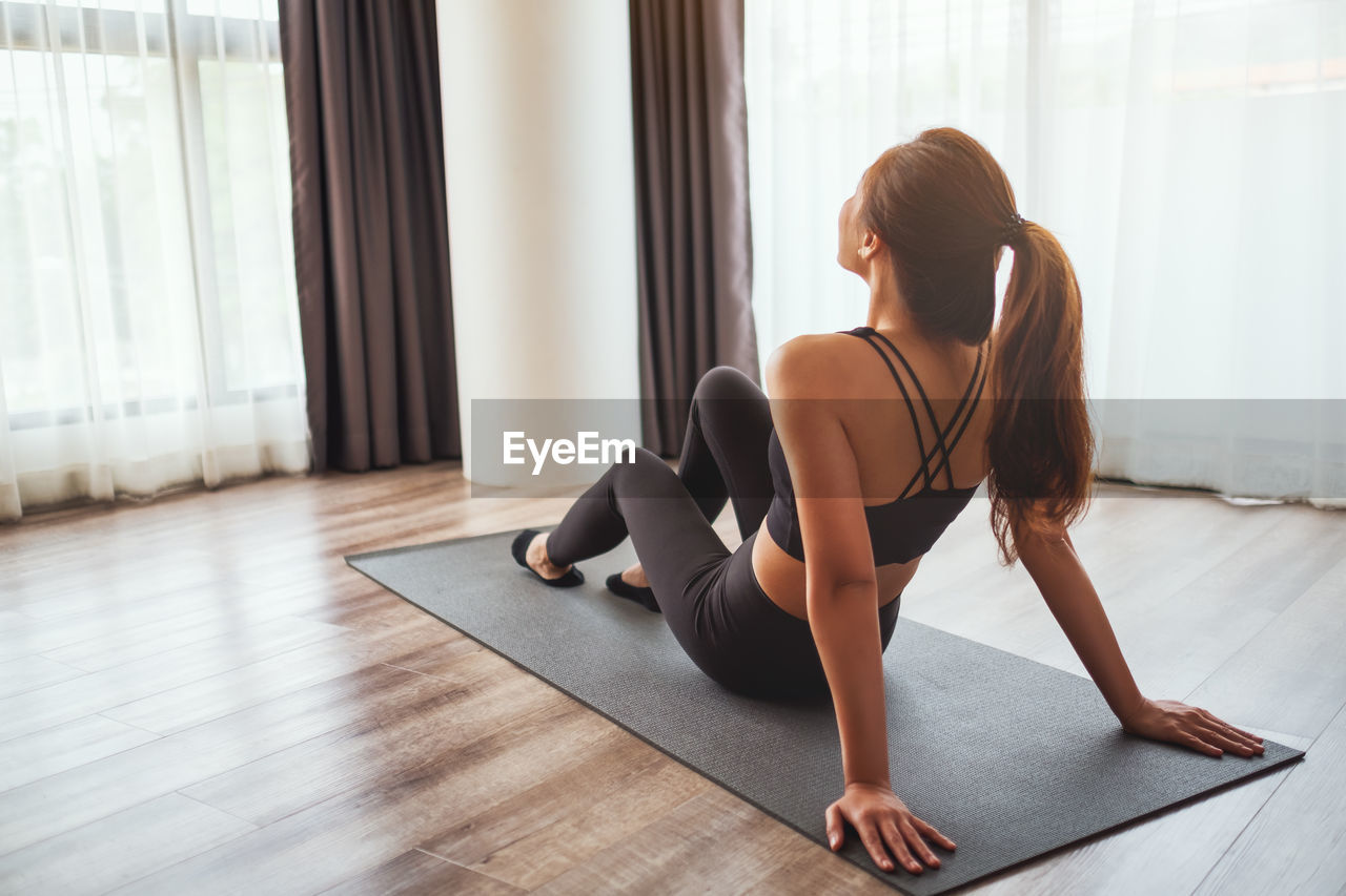 Rear view of woman exercising at home