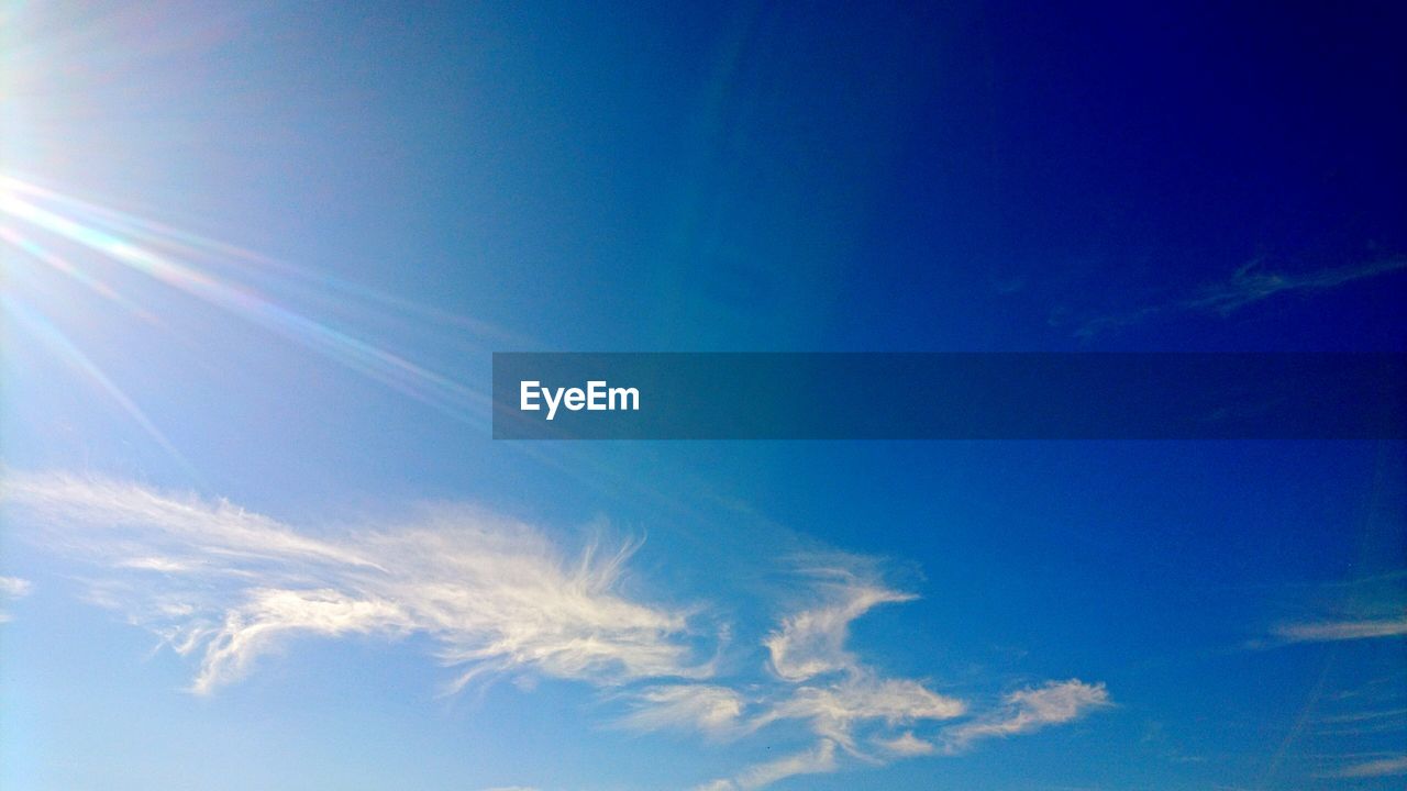 LOW ANGLE VIEW OF VAPOR TRAILS IN BLUE SKY