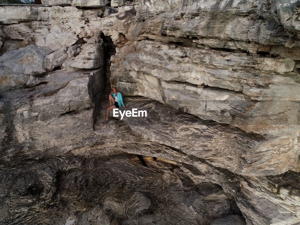 High angle view of woman sitting on rock formation