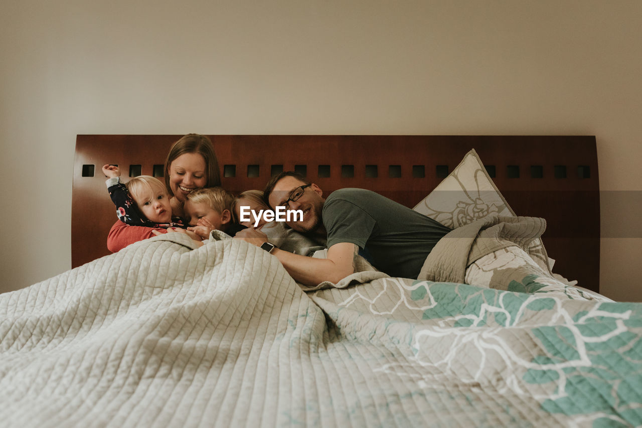 Happy family on bed at home