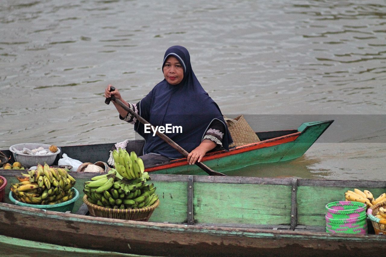 Woman selling food on boat in lake