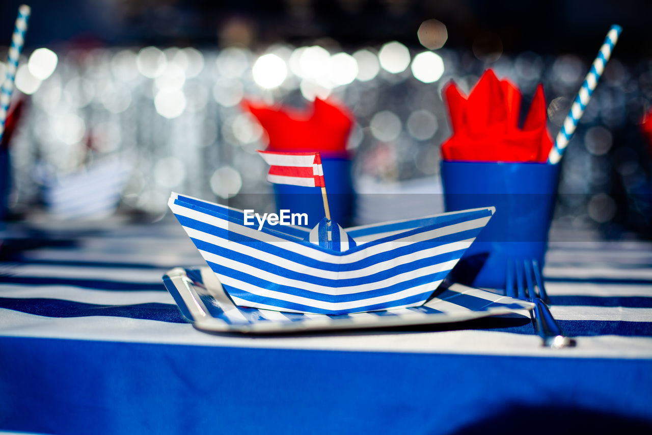 CLOSE-UP OF FLAGS ON TABLE AGAINST BLUE WALL