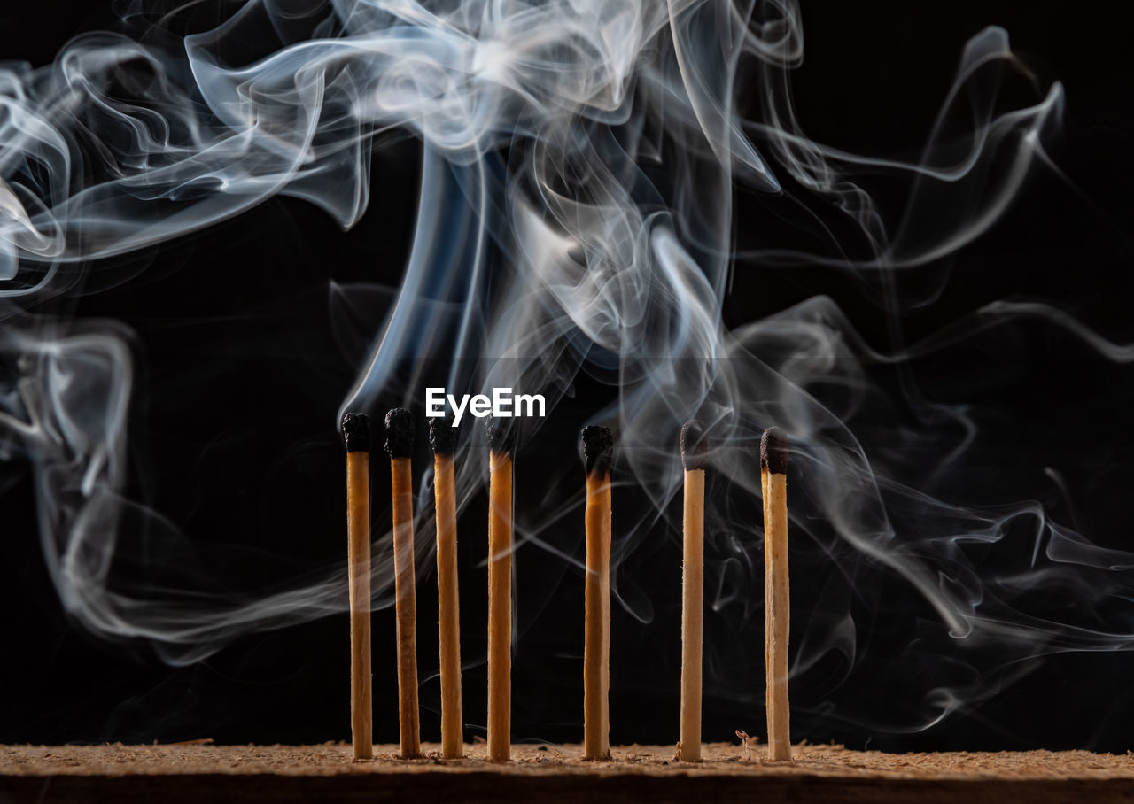 Close-up of emitting smoke against black background