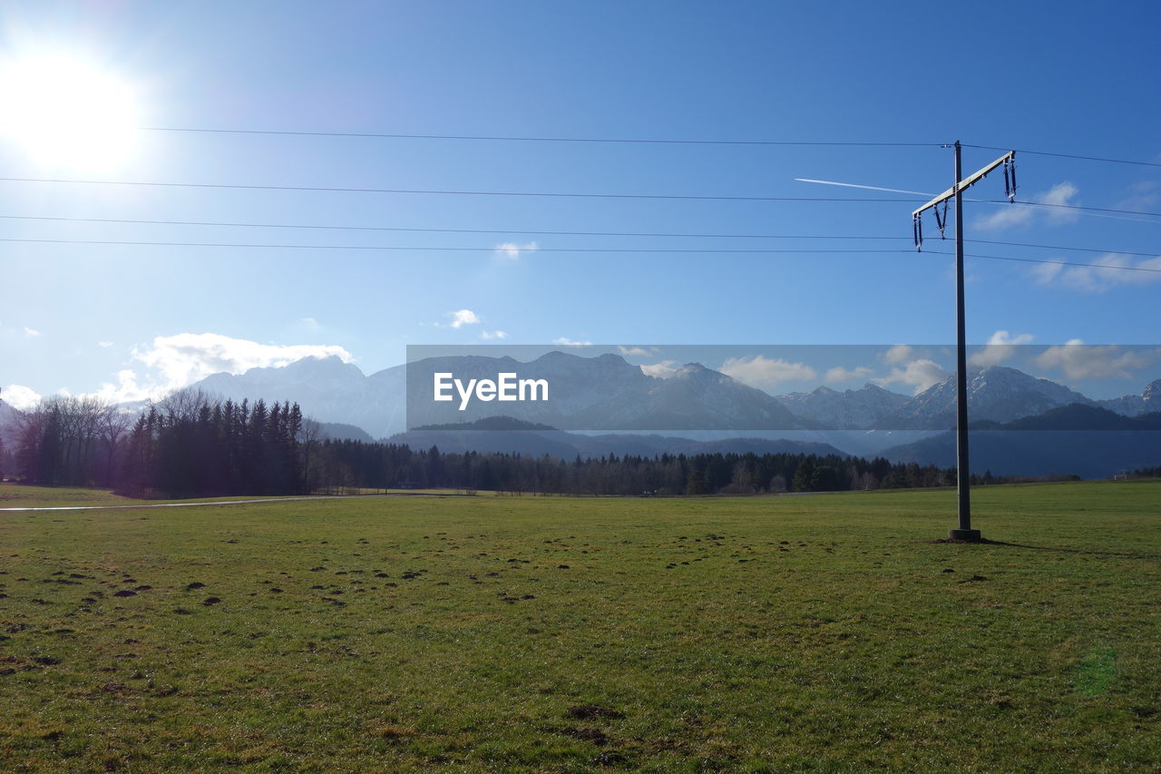 Scenic view of electricity pylon on field against sky