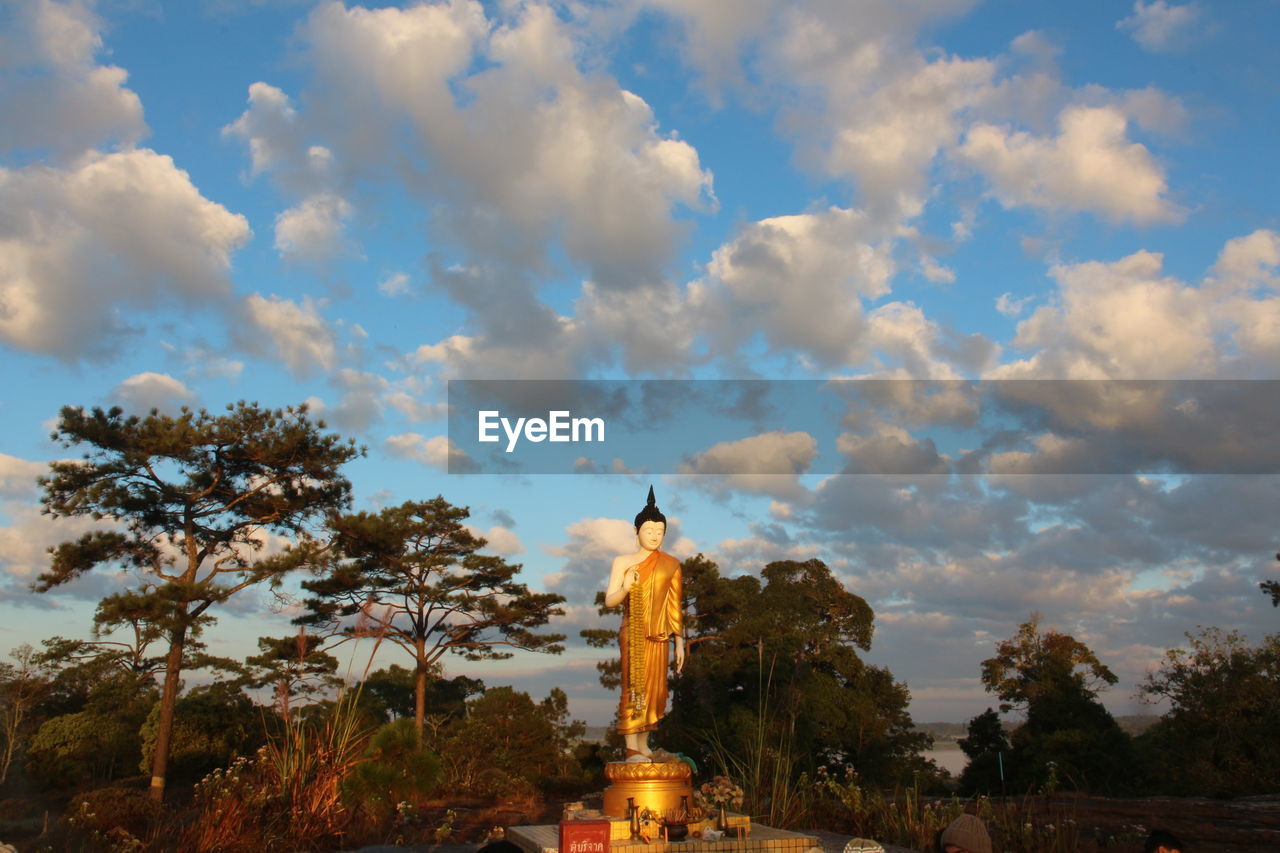 LOW ANGLE VIEW OF STATUES AGAINST SKY DURING SUNSET