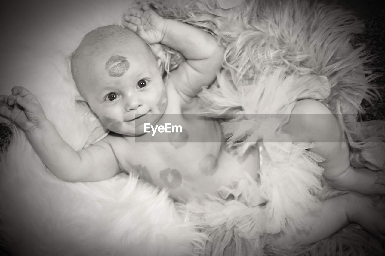 black and white, baby, child, childhood, monochrome photography, portrait, indoors, white, lying down, one person, monochrome, person, innocence, toddler, looking at camera, cute, portrait photography, emotion, female, women, human face, smiling, happiness, high angle view, bed, lying on back