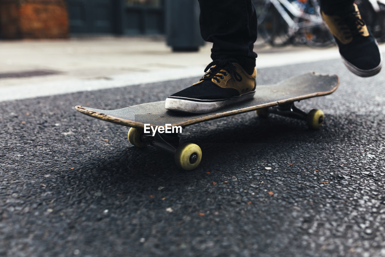 Young skateboarder on the street, partial view