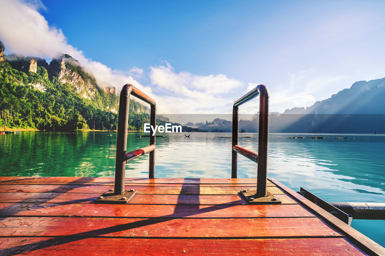 Scenic view of swimming pool by lake against sky