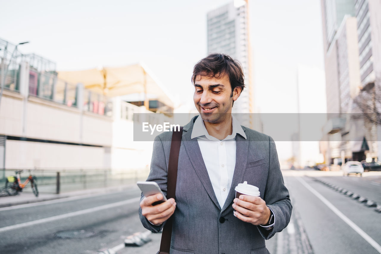 Young man using mobile phone in city