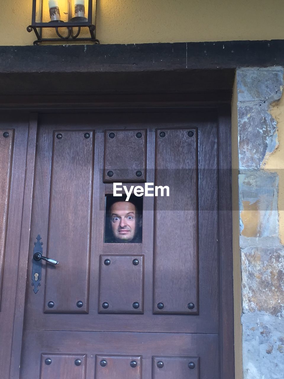 Portrait of man looking through closed door