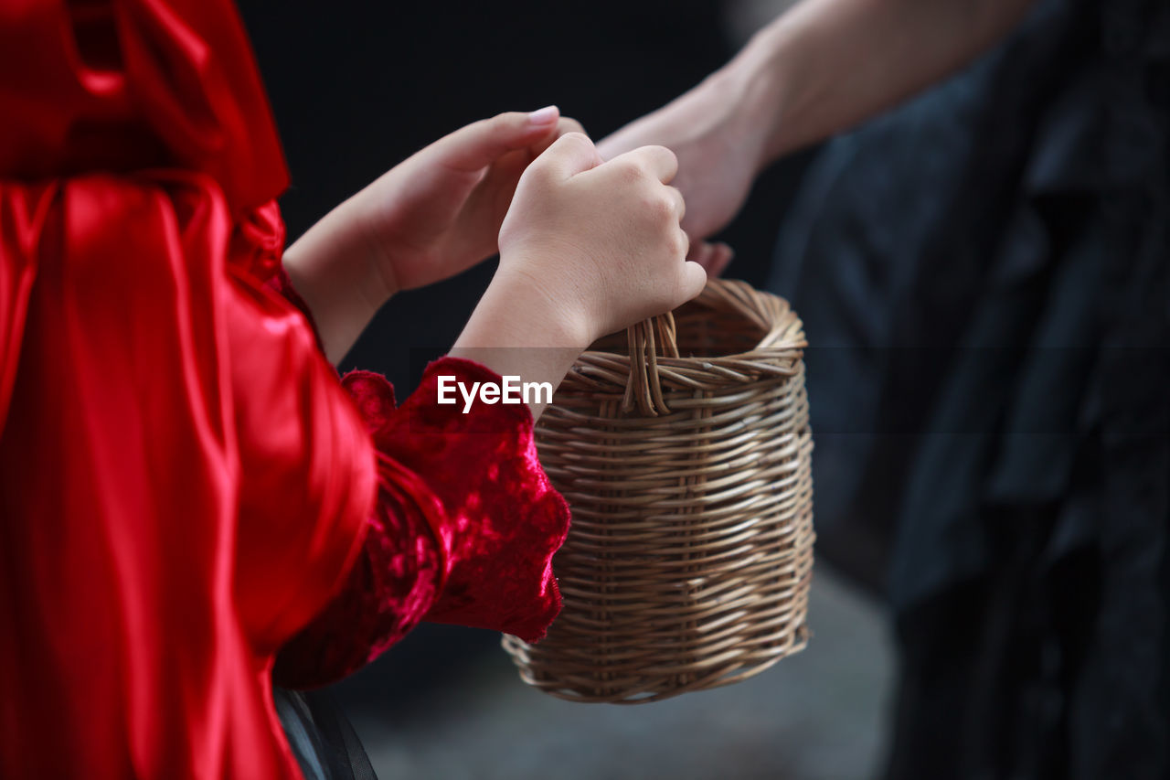 Midsection of child holding basket doing trick or treat