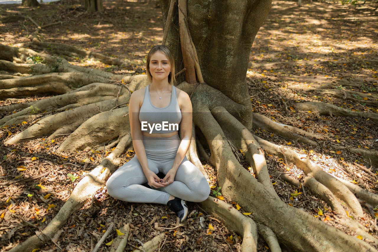 Young woman meditating. practice of yoga and meditation on a sunny day at a park, healthy, spiritual