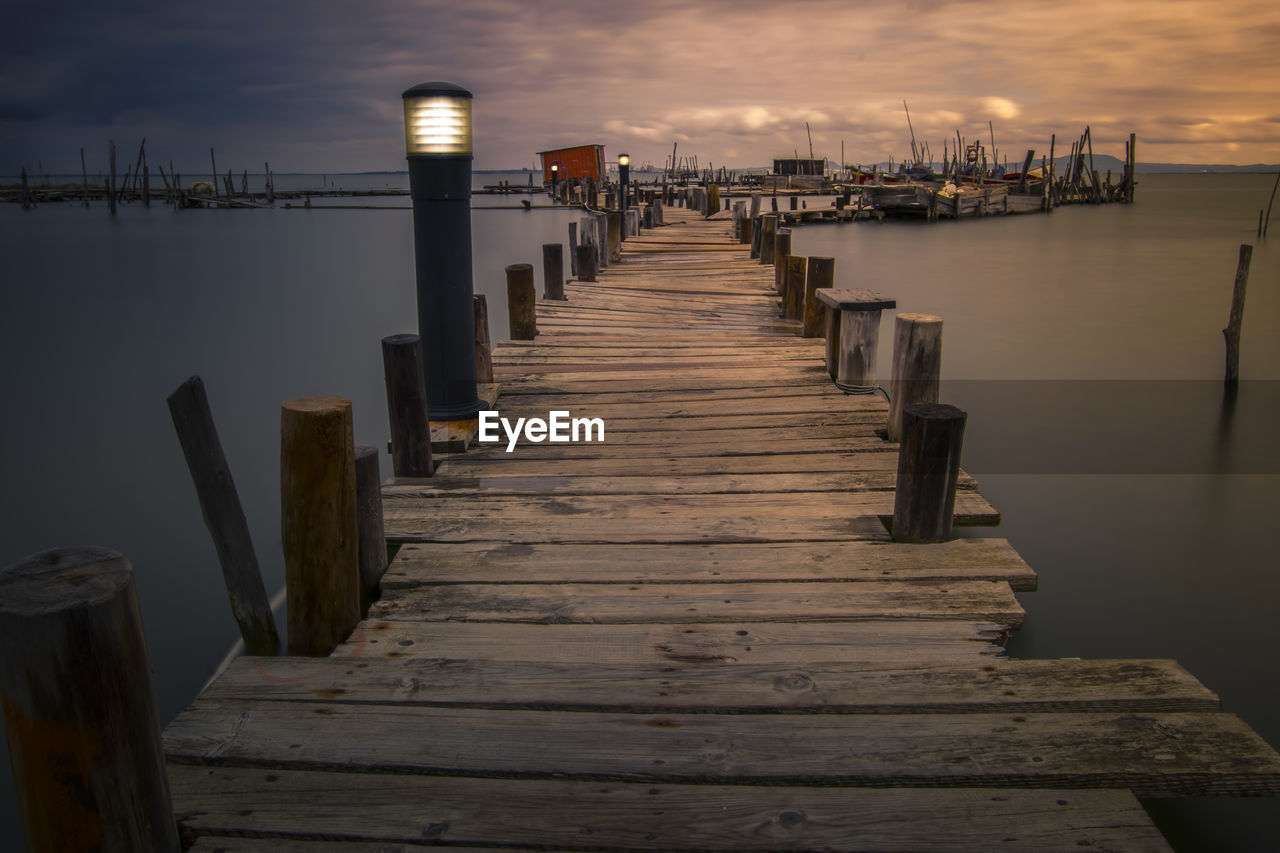 Wooden pier over sea against sky