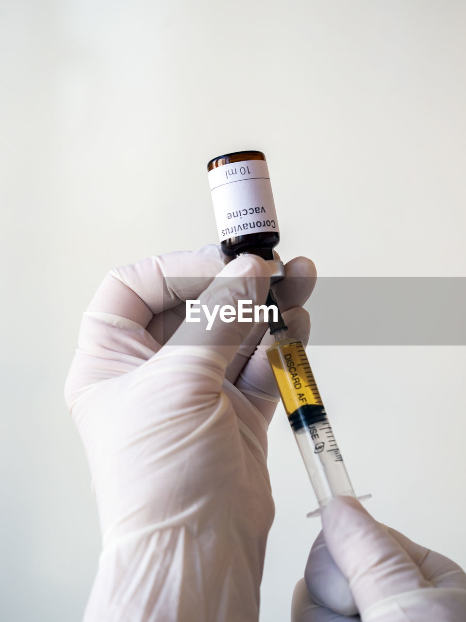 Doctor's hand holding a syringe of covid-19 vaccine and vaccine vial