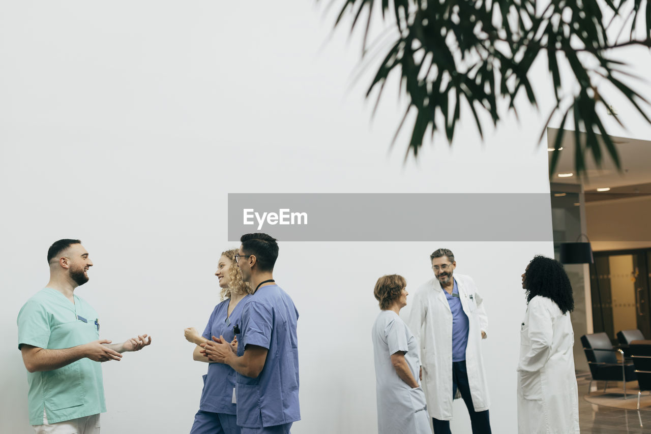 Team of male and female healthcare workers discussing with each other at hospital