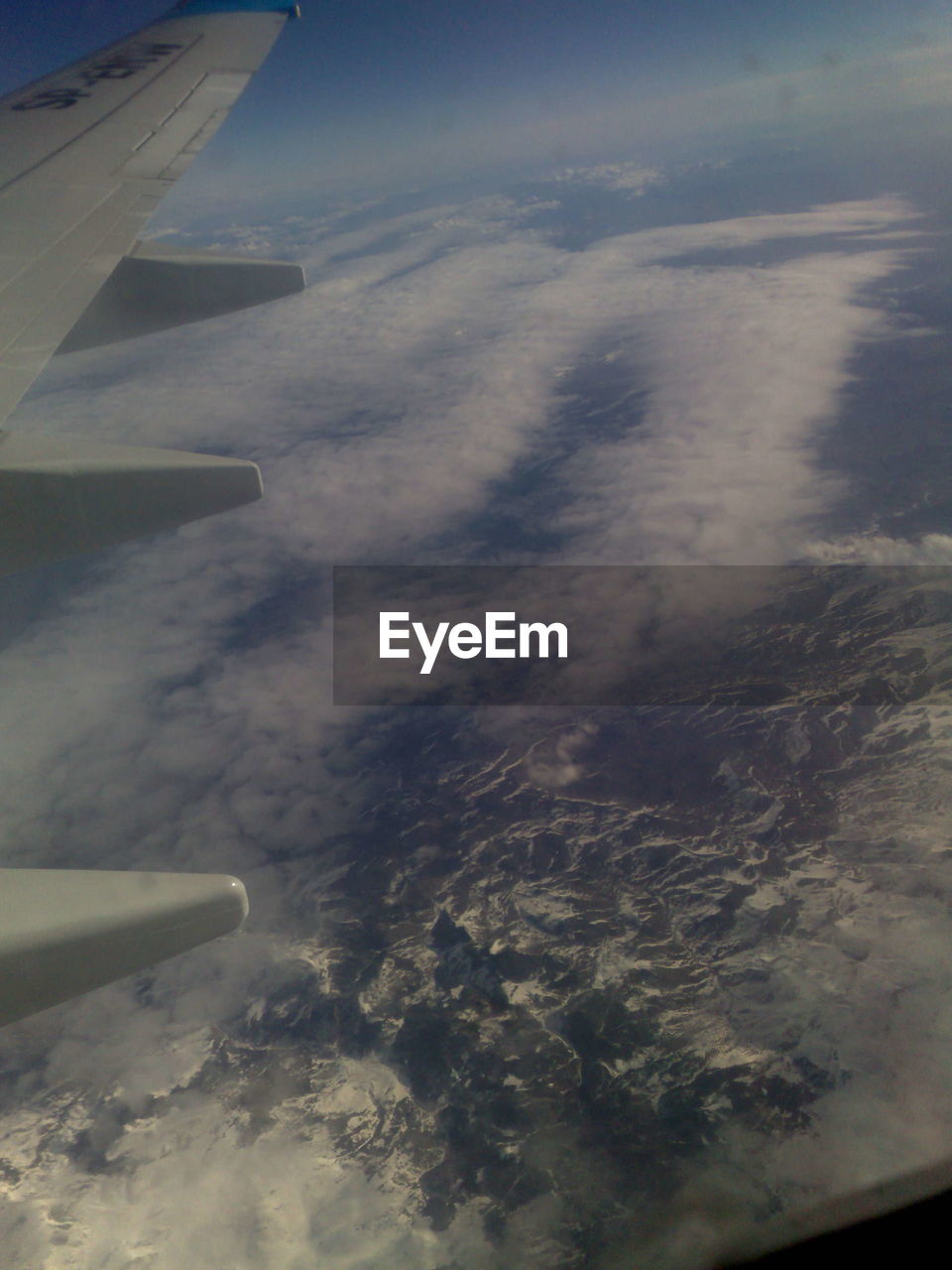 AERIAL VIEW OF AIRPLANE WING OVER CLOUDSCAPE